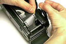 Dove manca il dispositivo di avanzamento automatico occorre verificare che il cilindro abbia saldamente agguantato la pellicola (Nikon).
